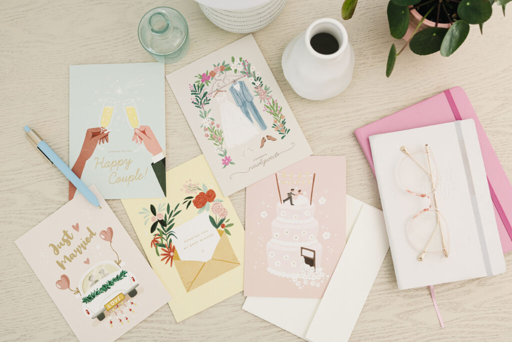 A wedding card with a blue pen and coffee on the side